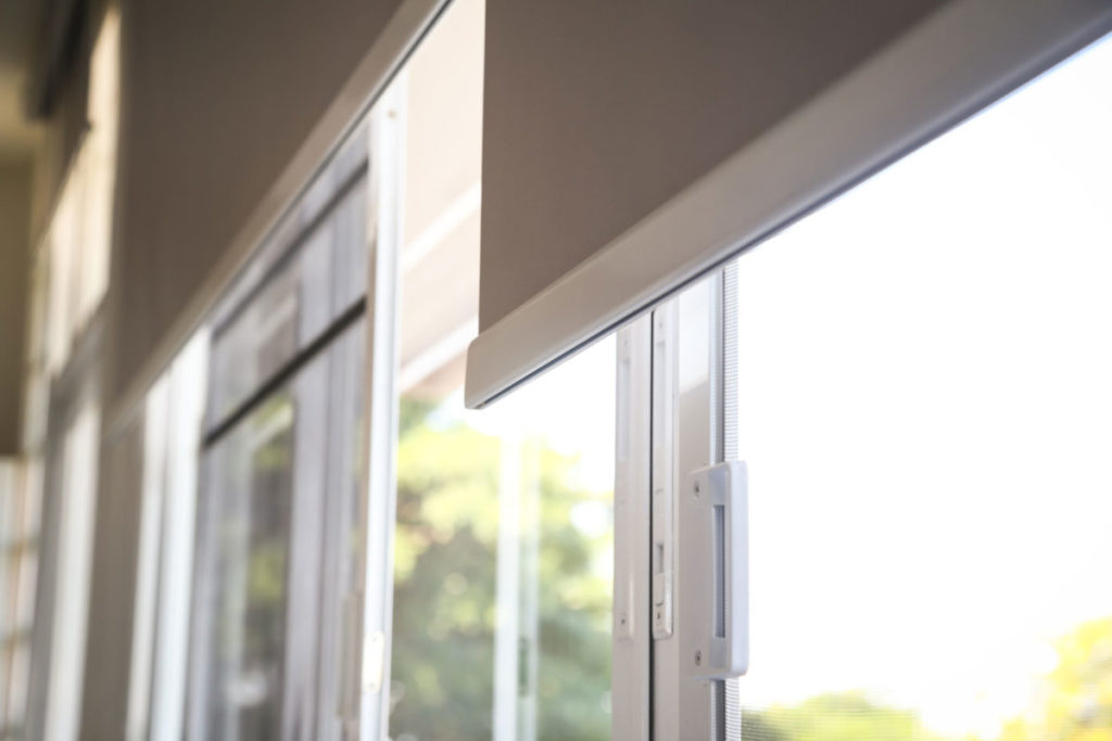 white fabric roller blinds on the plastic window
